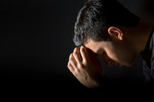 Young man praying in the dark